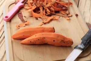 gepelde zoete aardappel op bamboe snijplank foto