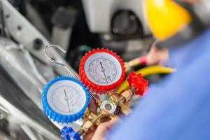 reparateur met monitortool om auto-airconditionersysteem te controleren en vast te maken, technicus controleert auto-airconditioningsysteem koelmiddel bijvullen, airconditioningreparatie foto