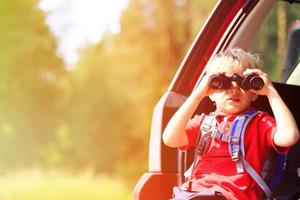 jongetje op zoek door middel van verrekijkers reizen met de auto foto