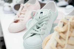 pastel sneakers op display plank voor verkoop bij sportwinkel in warenhuis. foto