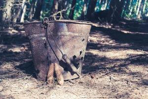 oude metalen emmer in een bos foto