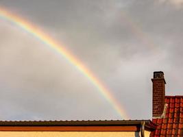 kleurrijke regenboog in een grijze bewolkte regenachtige lucht foto