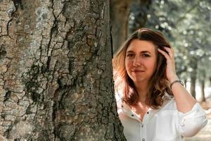 een mooie vrouw op een boomstam foto