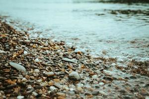 door water versleten kiezelstenen aan de rand van een meer foto