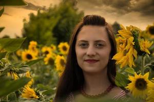 aantrekkelijke stijlvolle vrouw poseren tussen zonnebloemen foto