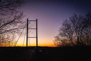 lage hoekmening van een silhouetbrug bij zonsondergang foto