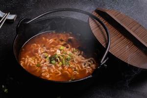 pittige koreaanse instant noedels met wakame zeewier in een zwarte ijzeren pot, koreaans eten in traditionele stijl foto