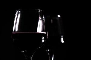 rode wijn in glas op de zwarte achtergrond foto