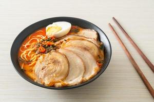 ramen noodles pittige tomyum soep met geroosterd varkensvlees foto