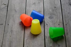 kleurrijke plastic bekers op een houten terras foto