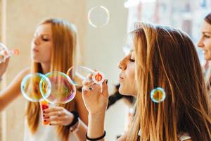 groep van drie vrienden spelen met zeepbellen foto