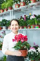 vrouw in bloemenwinkel met cyclaam