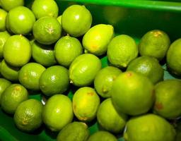 close-up van groene citroenen tentoongesteld in supermarkt foto