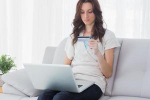 vrouw die online met haar laptop winkelt foto