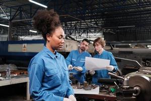 een professionele jonge vrouwelijke industriële ingenieur-werknemer werkt in een veiligheidsuniform met precisiegereedschappen voor metaalbewerking, mechanische draaimachines en een werkplaats voor reserveonderdelen in de staalfabriek. foto