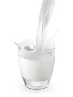 twee glazen melk gieten die plons creëren, geïsoleerd op een witte achtergrond foto
