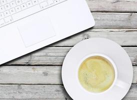 laptop en een kopje koffie met crema