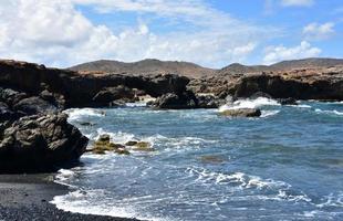 lavasteen op een zwart zandstrand in aruba foto