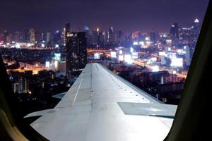avondvlucht op schemerhemel, geweldig uitzicht vanuit het raamvlak. stoel bij het raam op vliegtuig met uitzicht op de stad bij nacht uitzicht. foto
