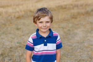 vijf jaar oude blanke kind jongen op hooi veld foto