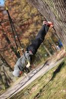 outdoor schorsing training in het bos - blanke man op boom