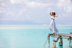blanke vrouw neemt rust op houten pier naar Indische Oceaan foto