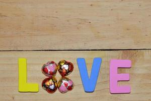 liefdesbrieven en chocolade hart op de houten vloer. achtergrond Valentijnsdag met harten. Valentijn concept. ruimte voor tekst. foto