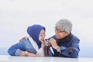 romantische senior paar zitten en samen thee drinken in een glas. gelukkig gepensioneerd echtpaar. foto