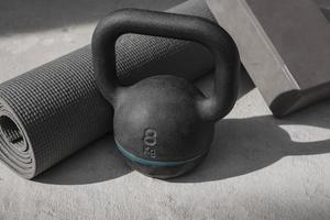 Kettlebell en yogamat op de vloer thuis. fitness apparatuur. foto