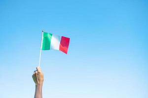 hand met de vlag van Italië op de achtergrond van de natuur. nationale dag, republieksdag, festa della repubblica en gelukkige vieringsconcepten foto