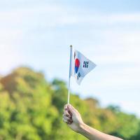 hand met korea vlag op de achtergrond van de natuur. nationale stichting, gaecheonjeol, nationale feestdag, nationale bevrijdingsdag van Korea en gelukkige vieringsconcepten foto