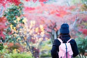gelukkige vrouwentoerist die in tenryuji-tempel in arashiyama reist, jong aziatisch reizigersbezoek in kyoto, japan. herfst herfst seizoen, vakantie, vakantie en sightseeing concept foto