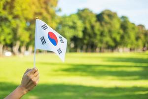 hand met korea vlag op de achtergrond van de natuur. nationale stichting, gaecheonjeol, nationale feestdag, nationale bevrijdingsdag van Korea en gelukkige vieringsconcepten foto