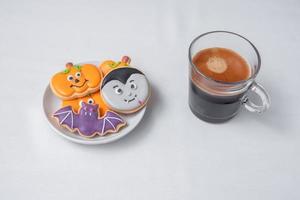 hete espressokoffie of chocoladekop met grappige halloween-koekjes. fijne halloween-dag, truc of bedreiging, hallo oktober, herfstherfst, traditioneel, feest- en vakantieconcept foto