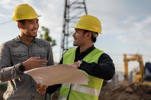 ingenieurs die op de bouwplaats werken. bouwmanager en ingenieursvergadering en discussie over project op de bouwplaats. foto