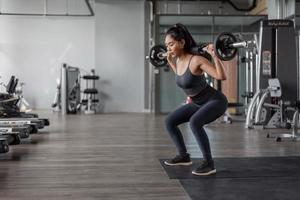 aziatische vrouw oefening in fitness. jonge gezonde vrouw in sportkleding doen benen oefening in fitness. foto