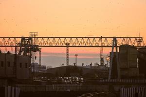 containerkraan op zonsondergangachtergrond foto