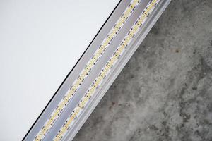 strip led-licht met aluminium profiel op spanplafond, close-up. huis renovatie concept foto