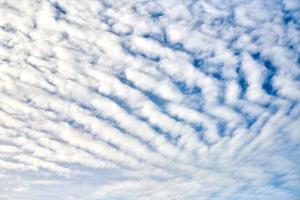 prachtige blauwe lucht met ongewone witte altocumulus undulatus-wolken, buitengewone wolkenformatie foto