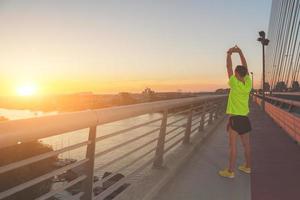 stedelijke jogger die zich uitstrekt over de brug foto