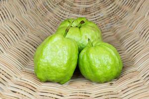 drie guave fruit op rotan achtergrond foto