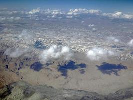 luchtfoto van landschapsbergen met sneeuw en cloudlscape van bovenaf foto