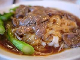 close-up roergebakken rijstnoedels met rundvlees en boerenkooljussaus op kantonese wijze foto