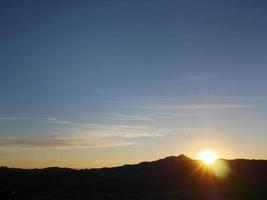 mooie zonlicht met silhouet berg donkere schaduw en blauwe lucht foto