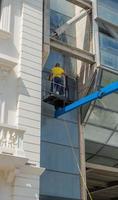 cattolica italy 2022glasreiniger in het winkelcentrum met behulp van het mobiele platform om de bovenste delen van het gebouw te bereiken foto