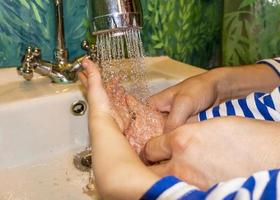 close-up van blanke man en kind wast zijn handen in de badkamer. covid - 19 preventie foto