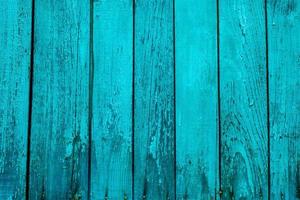 close-up van bekraste turquoise houten textuur van een hek. blauwe of groene houten planken foto