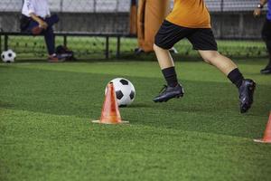 kinderen spelen controle voetbal tactieken op grasveld met voor training foto