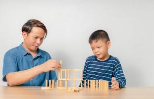 een jongen speelt thuis met zijn vader met een houten puzzel. foto