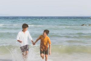 homoseksueel portret jonge aziatische paar lopen met vrolijk samen op het strand in de zomer, azië gay gaan toerisme voor vrije tijd en ontspannen met geluk in vakantie op zee, lgbt juridisch concept. foto